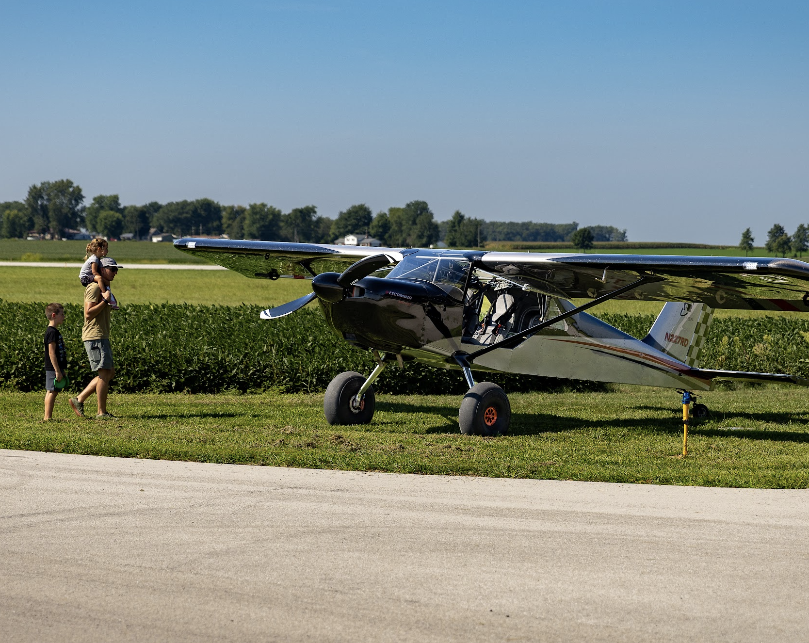 Visitors walk past a small airplane on display at the Runway Classic.